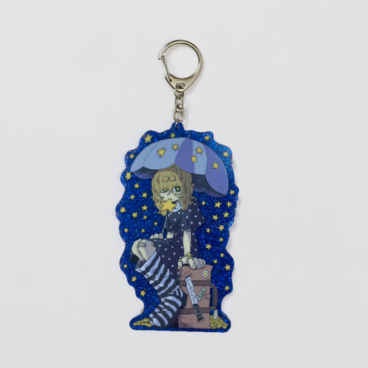 Keychain with a character holding an umbrella against a starry sky on a white background